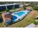 Aerial view of the community pool, patio, and shuffleboard court surrounded by manicured landscaping at 1450 Heather Ridge Blvd # 305, Dunedin, FL 34698