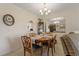 Charming dining area with a wooden table, blue cushioned chairs, and elegant chandelier lighting at 1450 Heather Ridge Blvd # 305, Dunedin, FL 34698