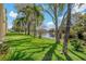 Scenic view of the community grounds, featuring a tranquil pond surrounded by lush greenery and mature trees at 1450 Heather Ridge Blvd # 305, Dunedin, FL 34698