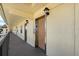 Exterior hallway showing a wooden elevator door, traditional lighting fixtures and dark handrails at 1450 Heather Ridge Blvd # 305, Dunedin, FL 34698