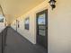 Exterior hallway featuring a dark-colored door with a window and traditional outdoor lighting fixture at 1450 Heather Ridge Blvd # 305, Dunedin, FL 34698