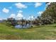 Scenic view of a serene pond surrounded by lush greenery and mature trees, adding natural beauty to the community at 1450 Heather Ridge Blvd # 305, Dunedin, FL 34698