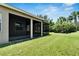 House exterior showcasing a screened patio and lush green lawn at 16028 Golden Lakes Dr, Wimauma, FL 33598