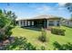 Home's backyard showcasing a screened porch and neatly landscaped yard at 16028 Golden Lakes Dr, Wimauma, FL 33598