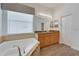 Spa-like bathroom featuring a corner tub and double vanity at 16028 Golden Lakes Dr, Wimauma, FL 33598