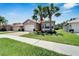 Two-car garage with palm trees and well-maintained landscaping at 16028 Golden Lakes Dr, Wimauma, FL 33598