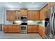 Modern kitchen with stainless steel appliances and wood cabinets at 16028 Golden Lakes Dr, Wimauma, FL 33598