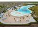 Aerial view of Crystal Lagoon amenity with sandy beach and cabanas at 16942 Trite Bend St, Wimauma, FL 33598