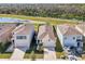 Three-house aerial view, showcasing neighborhood and landscaping at 16942 Trite Bend St, Wimauma, FL 33598