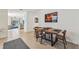 Modern dining area with a rustic wood table and four chairs, near entryway at 16942 Trite Bend St, Wimauma, FL 33598