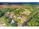 Aerial view of home with long driveway, lush lawn, mature trees, and screened pool at 1702 W Knights Griffin Rd, Plant City, FL 33565