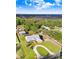 Expansive aerial view of a charming home with long driveway, lush landscaping, and screened pool at 1702 W Knights Griffin Rd, Plant City, FL 33565