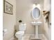 Stylish half bathroom with a pedestal sink, oval mirror, and tile flooring at 1702 W Knights Griffin Rd, Plant City, FL 33565