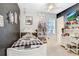 A quaint bedroom featuring neutral walls, a window, white furniture, and a white twin bed with a patterned quilt at 1702 W Knights Griffin Rd, Plant City, FL 33565