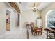 Dining area features white tile flooring, decorative wood beams, and a chandelier lighting the table with four chairs at 1702 W Knights Griffin Rd, Plant City, FL 33565