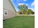 Well-maintained yard with green grass, mature trees, and neutral exterior colors at 1702 W Knights Griffin Rd, Plant City, FL 33565