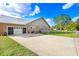 Home featuring neutral paint, a metal roof, and a concrete driveway leading to an attached garage at 1702 W Knights Griffin Rd, Plant City, FL 33565