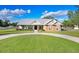 Inviting single-story home with a circular driveway, showcasing a neatly landscaped front yard at 1702 W Knights Griffin Rd, Plant City, FL 33565