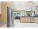 Well-lit kitchen with stainless steel refrigerator and view into eating area and living room at 1702 W Knights Griffin Rd, Plant City, FL 33565