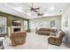 Spacious living room with a cozy fireplace, ceiling fans, and plenty of natural light at 1702 W Knights Griffin Rd, Plant City, FL 33565