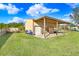 Outbuilding featuring a metal roof, a roll-up door, and a convenient open-air carport at 1702 W Knights Griffin Rd, Plant City, FL 33565