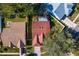 An aerial view of a home with a red roof in a suburban setting with surrounding green trees at 18529 Otterwood Ave, Tampa, FL 33647