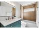 Modern bathroom with a stylish vanity, quartz countertop, brass accents, and shower over tub at 18529 Otterwood Ave, Tampa, FL 33647