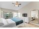 Bright main bedroom with a ceiling fan, slider to a covered porch, and a large gold-framed mirror at 18529 Otterwood Ave, Tampa, FL 33647