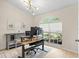 Bright and functional home office featuring a large window, modern desk, and comfortable seating creates a workspace at 18529 Otterwood Ave, Tampa, FL 33647