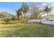 Large backyard with grassy area and mature trees at 18615 Yocam Ave, Lutz, FL 33549