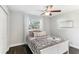 Well-lit bedroom with a white bed frame and dark floors at 18615 Yocam Ave, Lutz, FL 33549