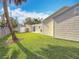 Exterior backyard view showcasing the well-manicured lawn, mature trees, and the home's unique architecture at 212 S Himes Ave, Tampa, FL 33609