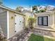 Backyard exterior view with a white shed, double doors, landscaping, and a connecting courtyard at 212 S Himes Ave, Tampa, FL 33609