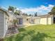 Expansive backyard featuring a pergola, white shed, manicured lawn, and a well-maintained exterior at 212 S Himes Ave, Tampa, FL 33609