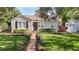 Charming home features a manicured lawn and a brick walkway to the front door at 212 S Himes Ave, Tampa, FL 33609