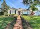 Beautifully landscaped front yard with lush green lawn, charming brick path, and cozy curb appeal at 212 S Himes Ave, Tampa, FL 33609