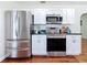 Kitchen featuring white cabinets, stainless steel appliances, and dark countertops at 212 S Himes Ave, Tampa, FL 33609