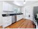 Kitchen featuring white cabinets, stainless steel appliances, subway tile backsplash, and hardwood floors at 212 S Himes Ave, Tampa, FL 33609