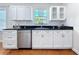 Kitchen featuring white cabinets, stainless steel appliances, subway tile backsplash, and hardwood floors at 212 S Himes Ave, Tampa, FL 33609