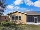 Rear view of a tan house with a screened patio at 2416 Kensington Greens Dr # 2416, Sun City Center, FL 33573