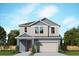 Two-story house with gray siding, beige garage door, and landscaping at 28965 Orange Berry Dr, Wesley Chapel, FL 33543