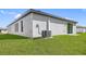 Newly built home with a grassy backyard and AC unit at 29543 Fedora Cir, Brooksville, FL 34602