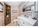 Modern powder room with a white vanity, wood shelving, and a stylish mirror at 2973 Somersworth Dr, Clearwater, FL 33761