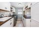 Laundry room with white cabinets, wood countertops, and stylish backsplash at 2973 Somersworth Dr, Clearwater, FL 33761