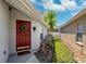 Inviting front entrance with a red door and decorative wreath, set amongst manicured landscaping at 31806 Larkenheath Dr, Wesley Chapel, FL 33543