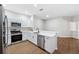 Bright kitchen featuring stainless steel appliances, white cabinets, and a breakfast bar at 31806 Larkenheath Dr, Wesley Chapel, FL 33543