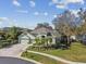 Single-story house with a two-car garage, lush landscaping, and a large backyard at 3710 Rain Tree Ct, Palm Harbor, FL 34685