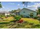 Backyard view of the home featuring a screened-in patio and manicured landscaping at 3710 Rain Tree Ct, Palm Harbor, FL 34685