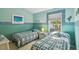 Bright bedroom features two twin beds, pale aqua walls, and cottage decor at 3710 Rain Tree Ct, Palm Harbor, FL 34685