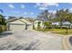 House exterior featuring a two-car garage and manicured landscaping at 3710 Rain Tree Ct, Palm Harbor, FL 34685